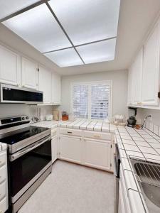 红木城Luxurious 2-bedrooms in Redwood + free parking的厨房配有白色橱柜和黑炉灶烤箱。