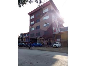 康格拉Hotel lords Highway Inn, Gagal Khas的一条高大的建筑,有汽车停在街边