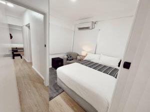 苏瓦Gladstone Gem 3 - Suva CBD 2bd Apt的卧室配有白色的床和镜子
