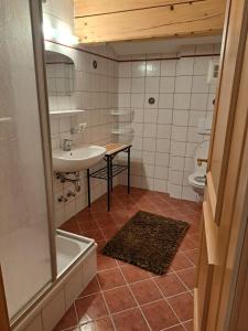 翁肯Berggasthof Hintergföll的一间带水槽、浴缸和卫生间的浴室