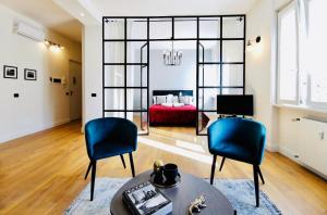 贝加莫F L O R E N T I N Design Apartment ChicLife的客厅配有2把蓝色椅子和红色沙发