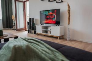 威廉港Südstrand, Zentral, Balkon, Wifi, Fahrstuhl, Parken的客厅配有白色橱柜上的平面电视
