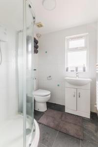 BansteadSurrey Stays - 4 bedroom house, sleeps 9, 2 bathrooms, CR5, near Gatwick Airport的白色的浴室设有卫生间和水槽。