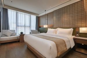 东莞塘厦华漫酒店的酒店客房设有一张大床和一张沙发。