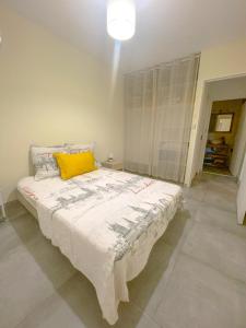 FilaosL'Hermitage - Appartement T3 en bord de plage的一间卧室配有一张带黄色枕头的大床