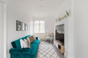 寇斯顿Surrey Stays - 5bed house, sleeps 12, CR5, near Gatwick Airport的客厅配有绿色沙发和桌子
