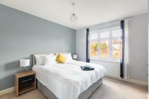 寇斯顿Surrey Stays - 5bed house, sleeps 12, CR5, near Gatwick Airport的卧室设有一张白色大床和一扇窗户。