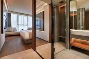 东莞塘厦华漫酒店的浴室设有床、水槽和镜子