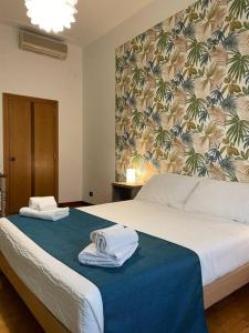 罗马"La Piccola Londra "appartamento a Roma 5 minuti da piazza del Popolo的一间卧室配有带毛巾的床