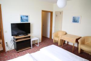 克夫拉赫Hotel Reinisch的配有一张床和一台平面电视的酒店客房