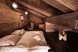 什切尔克Le Chalet Skalite的一间带一张大床的卧室,位于带木墙的房间