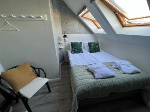 锡姆里斯港Rörums Gårdshotell的阁楼卧室配有床和椅子