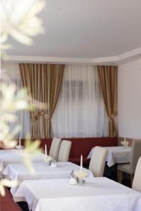 里菲亚诺Pension Kleon的用餐室配有白色的桌子和白色的椅子