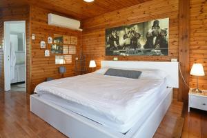 Manot比托诺费度假屋的卧室配有一张白色的木墙床