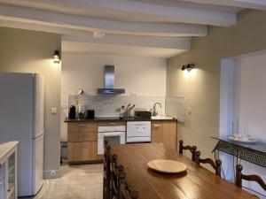 舍农索城堡Le Loft - Chenonceaux - 3 étoiles的厨房配有木桌和冰箱。