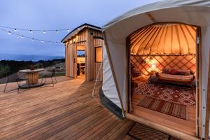 Adventure BayLuxury yurt glamping at Littlegrove的甲板凉亭里的冰屋床