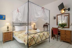 GrikosGrikos Hotel的一间卧室配有一张天蓬床和一张书桌