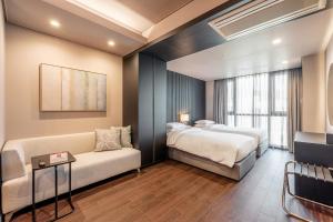 釜山海云台中心酒店的酒店客房,设有两张床和一张沙发