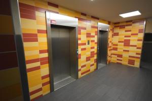 柏林Apartment Isabella的建筑里带彩色瓷砖墙和电梯的走廊
