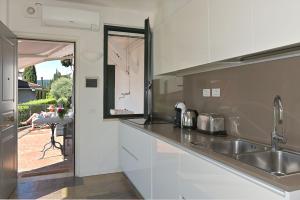萨罗Villa Raoul的厨房配有白色橱柜、水槽和桌子