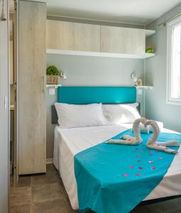 索托马里纳Camping Atlanta & Mediterraneo Family Village的一间卧室配有一张带两个天鹅的床