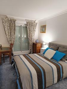 德勒Appartement Dreux的一间卧室配有一张床、一张书桌和一个窗户。