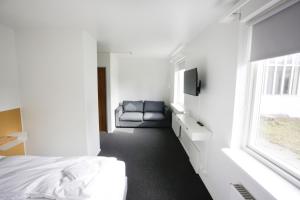 EiðarEiðar - Hostel的卧室配有床、椅子和窗户。