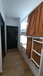 阿利坎特VAD HOSTEL ALICANTE的一间小房间,配有冰箱和木地板