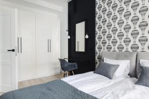托伦Manpro Apartments Toruń的一间卧室配有一张床和一面镜子的墙壁