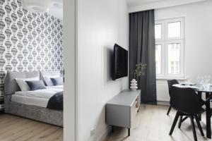 托伦Manpro Apartments Toruń的一间卧室配有一张床,另一间用餐室配有桌子