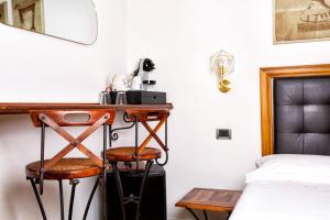 博洛尼亚科斯莫伊B＆B酒店的一间卧室配有书桌、一张床、一张床铺和凳子