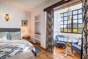 维拉努埃瓦·德·塔皮亚La Bobadilla, a Royal Hideaway Hotel的一间卧室配有一张床、一张桌子和一个窗户。