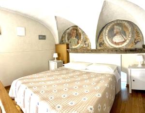 贝加莫Bramantesco的卧室配有一张床,墙上挂有两张照片