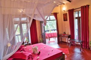 本托塔Sri Lancashire Guest House的一间卧室配有粉红色的床和粉红色的天篷