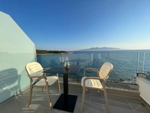 萨兰达Sea Breeze Villa的阳台配有桌椅,享有水景