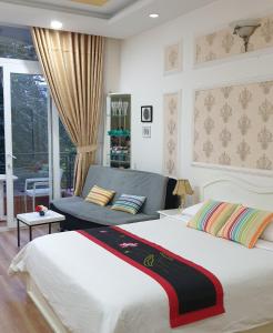 胡志明市Chez Lotus Rose的一间卧室配有一张大床和一张沙发