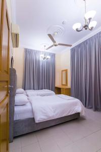 海塞卜Esra Hotel Apartment的一间卧室配有一张大床和紫色窗帘