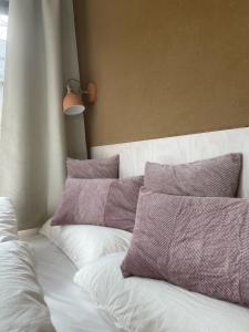 哈嫩克利博克斯维斯Cozy Cabins I Tiny House Seecontainer的一张带紫色和白色枕头的床