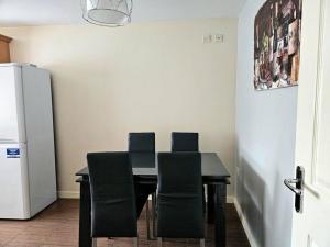 利物浦Baltic Gem 4 Bedroom Townhouse with free parking的餐桌、椅子和冰箱