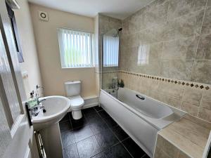 利物浦Baltic Gem 4 Bedroom Townhouse with free parking的一间带水槽、浴缸和卫生间的浴室