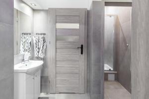 弗罗茨瓦夫VICE CITY Hostel的带淋浴和白色盥洗盆的浴室