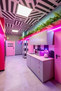 弗罗茨瓦夫VICE CITY Hostel的一间粉红色的厨房,室内配有粉红色的灯光