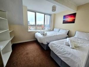 利物浦Baltic Gem 4 Bedroom Townhouse with free parking的一间卧室设有两张床和窗户。