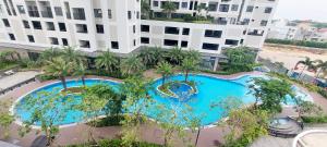 Dĩ AnLuxury Apartment - Charm Ruby, Di An的大楼前游泳池的顶部景色