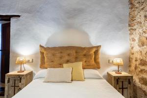 圣埃乌拉利亚Can Mateu的卧室配有带两盏灯的白色床