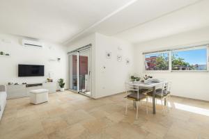 圣玛丽亚纳瓦雷Melania Holidays Home - Sole Incantatore的白色的客厅配有桌椅