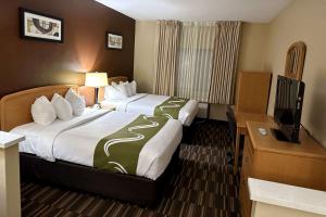 法戈Quality Suites Near West Acres的酒店客房设有两张床和一台平面电视。