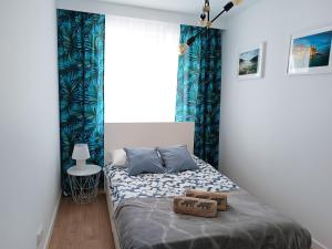 托伦Apartament nr15 z parkingiem podziemnym的一间小卧室,配有一张带蓝色窗帘的床