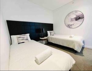 悉尼Chatswood Exeutive Suites - 3beds2baths的一间卧室设有两张床,墙上设有一面镜子