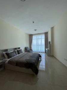 阿吉曼Lovely 2 BHK just 2 min from the beach的一间卧室设有一张大床和一个大窗户